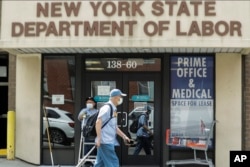 Pejalan kaki melewati lokasi kantor Departemen Tenaga Kerja Negara Bagian New York Kamis, 11 Juni 2020. (AP/Frank Franklin II)