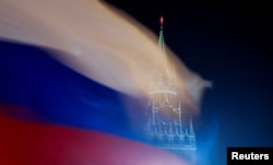 Bendera Rusia berkibar dengan latar belakang Menara Spasskaya Kremlin Moskow di Rusia 27 Februari 2019. (Foto: REUTERS/Maxim Shemetov)