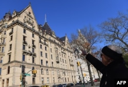 Susan Ryan, yang memimpin tur jalan kaki Beatles di sekitar New York, menunjuk ke gedung apartemen The Dakota, tempat tinggal John Lennon dan Yoko Ono, di seberang Central Park di New York City, 3 Desember 2020. (Angela Weiss / AFP)