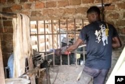 Karyawan Anathole Kisakye, mengekstraksi benang serat pisang menggunakan mesin bengkel Tupande Holdings Ltd, di Desa Kiwenda, Busukuma, Kecamatan Wakiso. Uganda, Rabu, 20 September 2023. (AP/Hajarah Nalwadda)